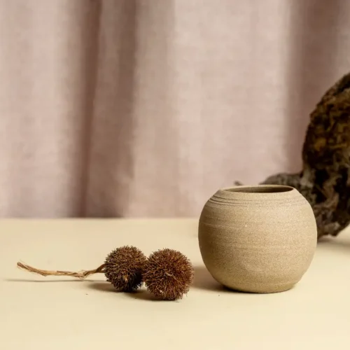 כלי קרמיקה עגול בגוון חום טבעי על רקע בהיר.